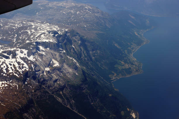 вид с самолета на гору и море в норвегии - mountain range earth sky airplane стоковые фото и изображения