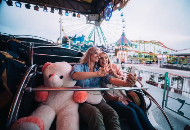 istock Mature women taking selfies on amusement park roller coaster ride 990122854