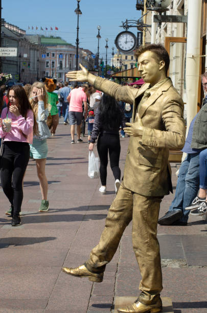 St. Petersburg, Russia - July 23, 2017: Street artist depicts a Golden statue on Nevsky prospect
