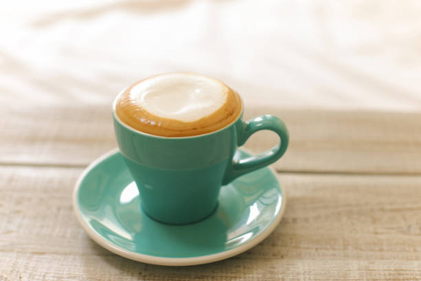 istock Hot coffee cappuccino isolated on wooden table 990134980