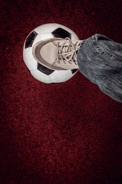 istock soccer ball and foot on a red artificial surface 990174950
