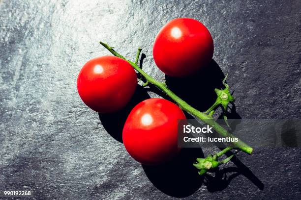 Three Tomatoes On Slate Surface Argb Stock Photo - Download Image Now - Slate - Rock, Tomato, Close-up