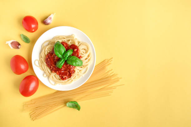 istock Spaghetti pasta bolognese on yellow 990201474