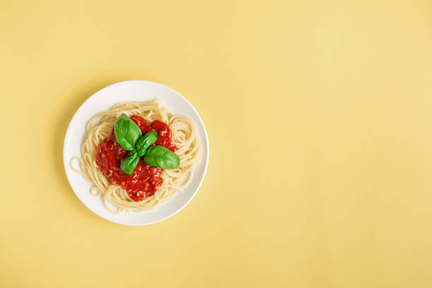 istock Spaghetti pasta bolognese on yellow 990201476