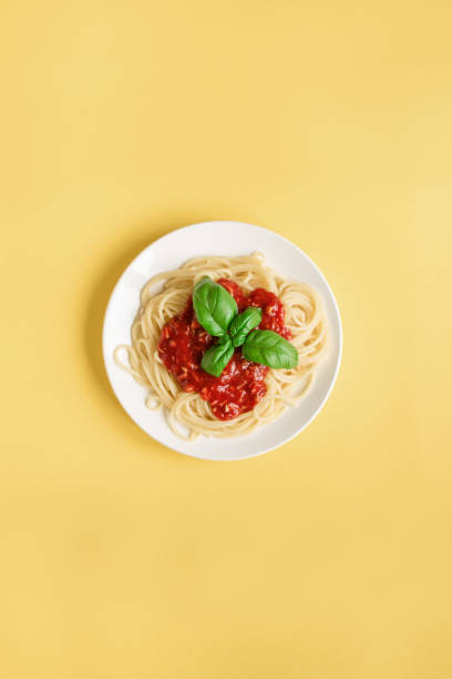 istock Spaghetti pasta bolognese on yellow 990201478