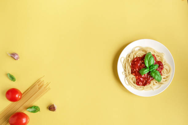 istock Spaghetti pasta bolognese on yellow 990201488