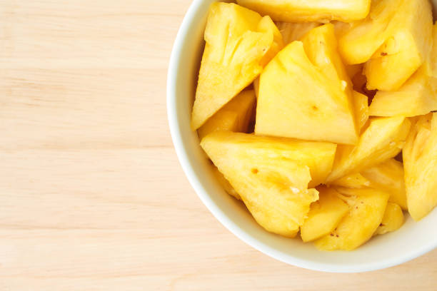 istock Pineapple on a plate placed on a wooden table. 990211316