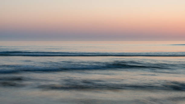 hermoso amanecer vibrante colorido sobre escena tranquila del paisaje de la playa de bajamar - bamburgh northumberland england beach cloud fotografías e imágenes de stock