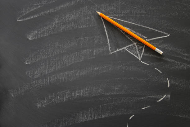 istock Top view image of sketch plane and pencil over classroom blackboard background. 990227150