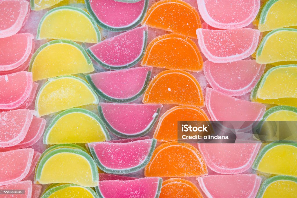 Jelly Marmalade Candies of Various Colors in Shape of Citrus Fruits Watermelon Wedges. Vivid Multicolored Palette Orange Yellow Green Red Pink. Pattern Wallpaper High Resolution Banner. Birthday Backgrounds Stock Photo