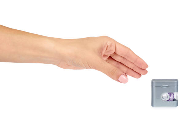 istock Dental floss in grey container with hand isolated on white background. 990263206