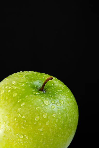 istock top of green wet fresh Apple on black background 990263408