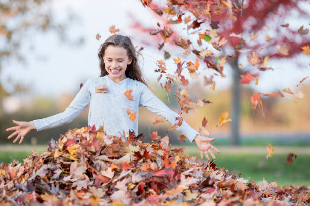 istock Girl Playing In Leaves 990269544