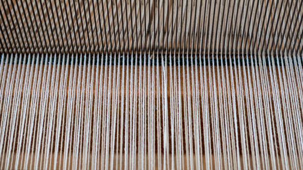 istock Vintage handloom weaving machine, with focus on the pattern created by the interlaced cotton yarn 990278596