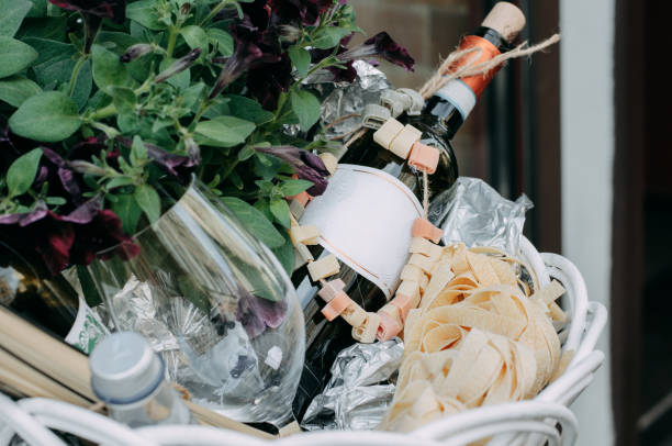 The red wine unopened bottle, glass and blossom flowers in the white basket stock photo