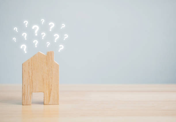 istock Wooden home shape with question mark on wood table and copyspace for your text. Ideas house concept 990286080
