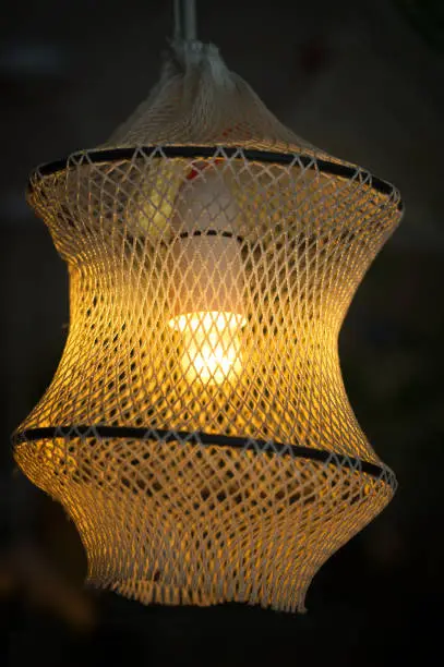 Beautiful fishnet lamp in a dark room.