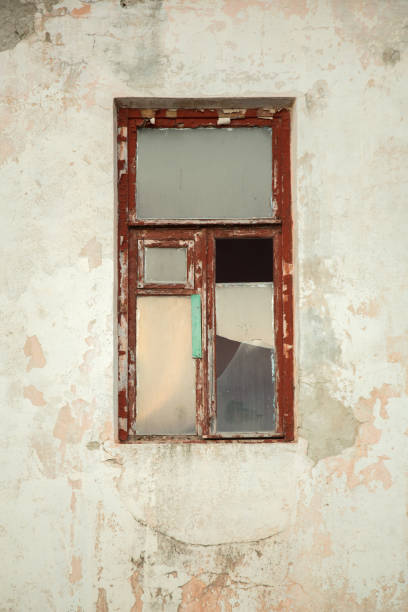 istock The wall of an old house with a broken window 990309146