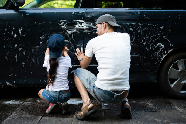 istock Father and daughter wash the car 990309620
