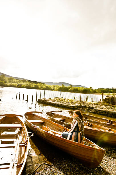 seul passager à bord d’un bateau coloré / canoë de waterside - lakedistrict photos et images de collection