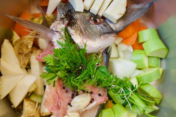 istock Closeup raw fish steak with vegetables on plate 990319018