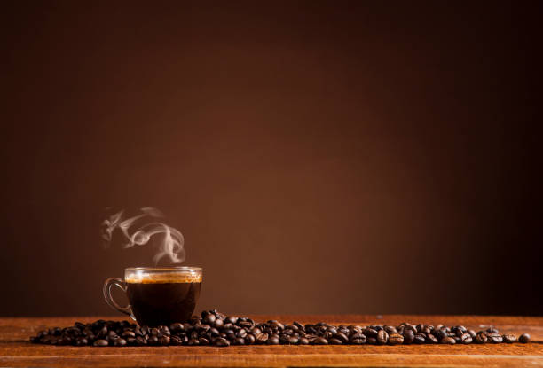 Coffee on a brown background with copy space Glass coffee cup and coffee beans on old wooden table and brown background with copy space cafe transparent glass table stock pictures, royalty-free photos & images
