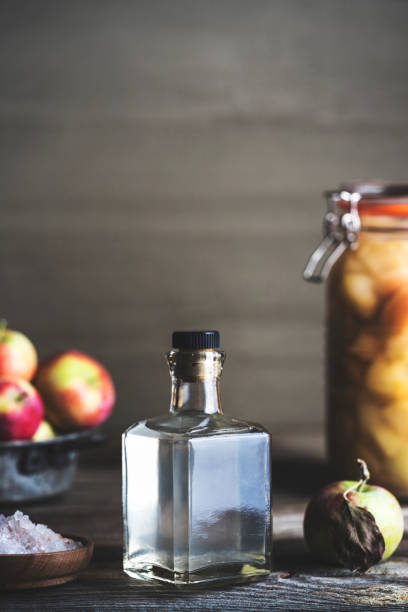istock Bottle of apple cider vinegar on rustic background 990339988