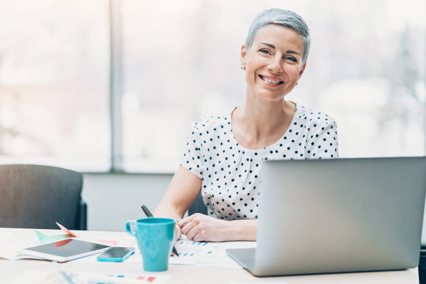 Smiling businesswoman Elegant businesswoman sitting in her office, with copy space women satisfaction decisions cheerful stock pictures, royalty-free photos & images