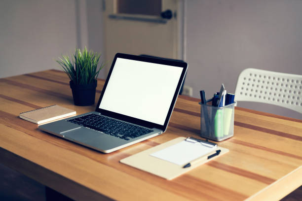 istock Laptop on table in the office room background, for graphics display montage. Take your screen to put on advertising. 990347632