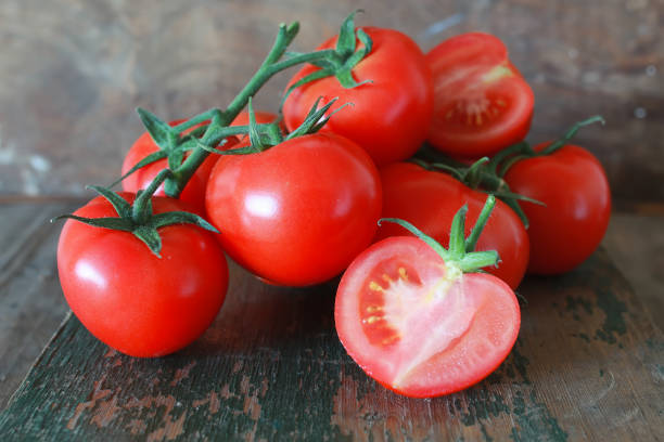 istock branch of tomatoes on wooden background 990352276
