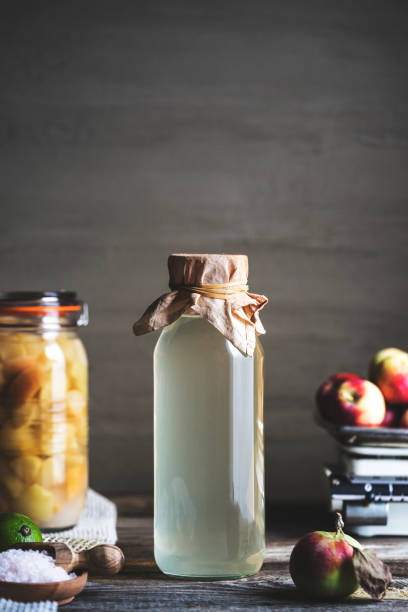 istock Bottle of apple cider vinegar on rustic background 990361658