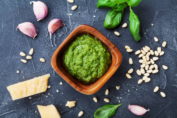 istock Fresh ingredients and green pesto sauce on black stone table from above. 990362024