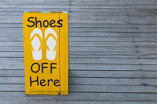 No shoes sign on the wooden floor in yellow color Thailand