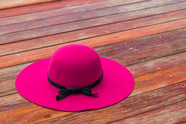 Beautiful pink hat with black bow on a wooden floor Thailand