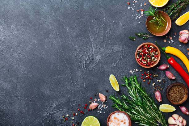 istock Different spices and herbs on black stone table top view. Ingredients for cooking. Food background. 990365366