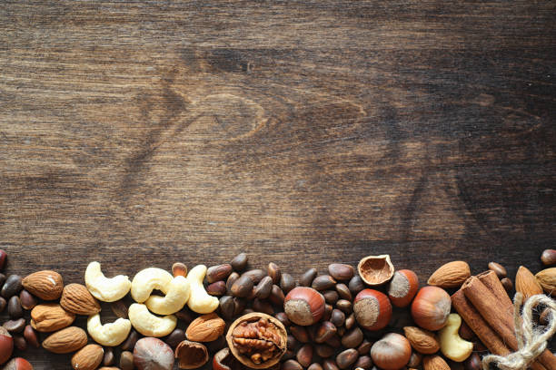 istock Different nuts on a wooden table. Cedar, cashew, hazelnut, walnu 990370102