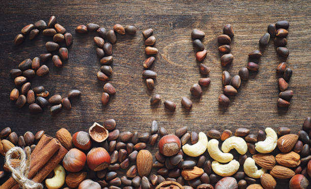 istock Different nuts on a wooden table. Cedar, cashew, hazelnut, walnu 990370402