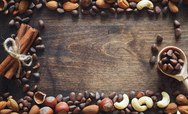 istock Different nuts on a wooden table. Cedar, cashew, hazelnut, walnu 990370612