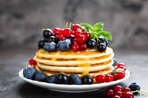 istock Pancakes with fresh berries. Pancakes with raspberry, blueberry, redcurrant, black currant and honey 990375270