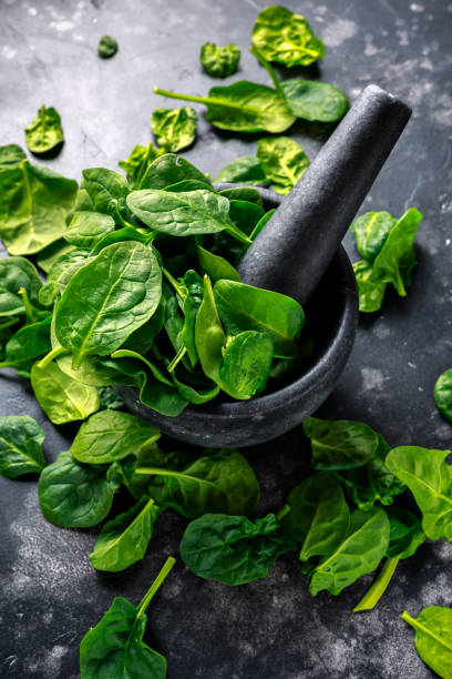 istock Fresh organic spinach leaves in marble pestle ready for pesto making 990375812