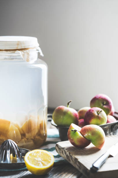 istock Bottle of apple cider vinegar on rustic background 990376058