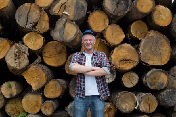 adultos satisfecho leñador de pie delante de la gran pila de madera - lumberjack shirt fotografías e imágenes de stock