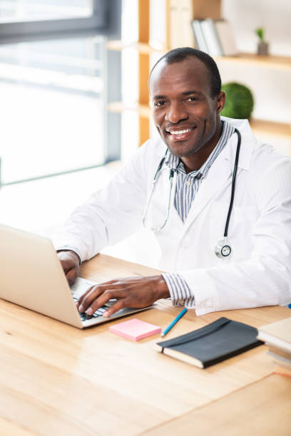 istock Pleased brunette sitting at his workplace 990384016