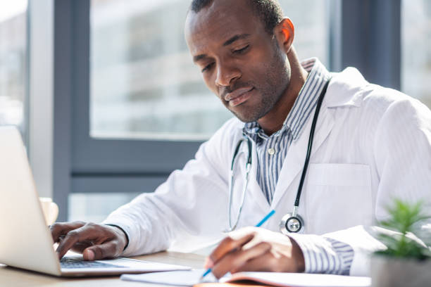 istock Attentive medical worker making notices 990384106