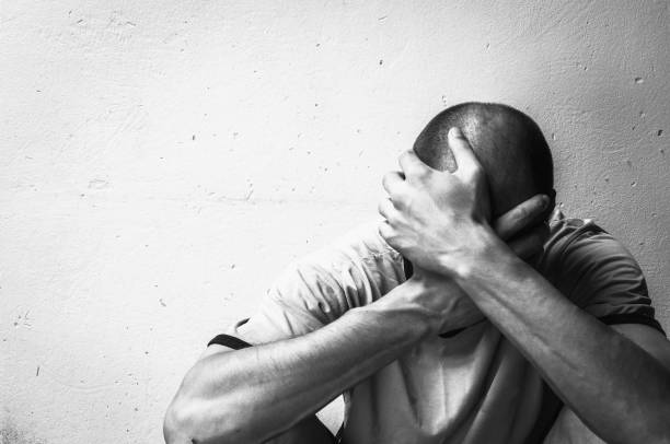 hombre sin hogar de drogas y alcohol adicto de estar solo y deprimido en la calle sintiendo ansioso y solitario concepto de documental social blanco y negro - adicción fotografías e imágenes de stock