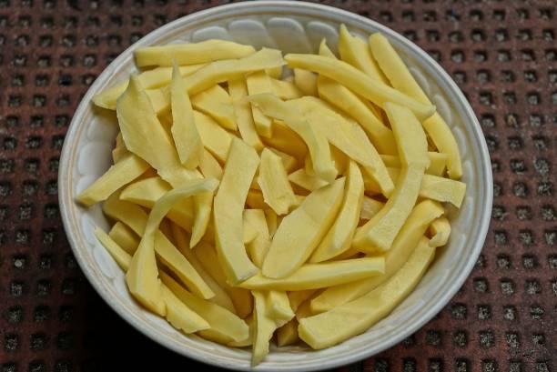 istock raw pieces of potatoes in a white plate on a table 990427498