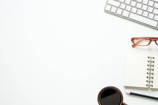 istock Top view office desk with computer, pencil, glasses, notebook paper and coffee cup. 990439978