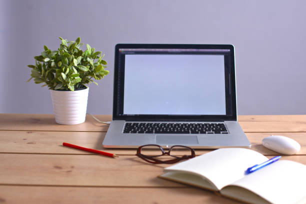 istock Laptop stands on a wooden table 990443184