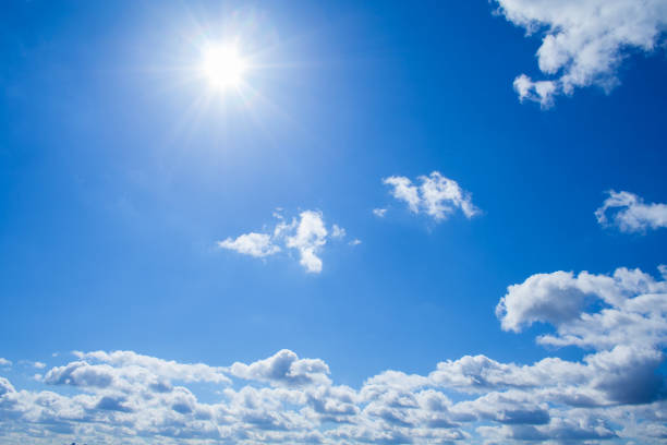 istock View of a fluffy clouds and sun in bright azure sky 990445374