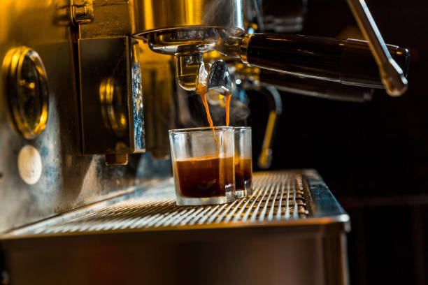 istock Brewing coffee from an espresso machine to a graduated shot cup 990451126